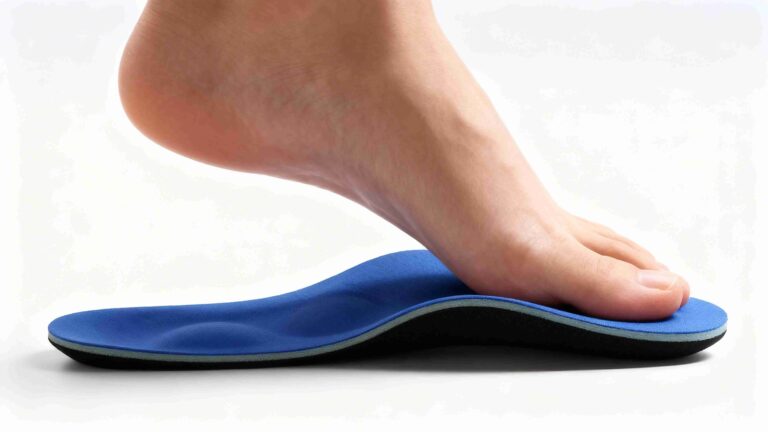 Adult standing in athletic shoes with supportive insoles, showing proper foot alignment and neutral spine posture on a clean clinical background.