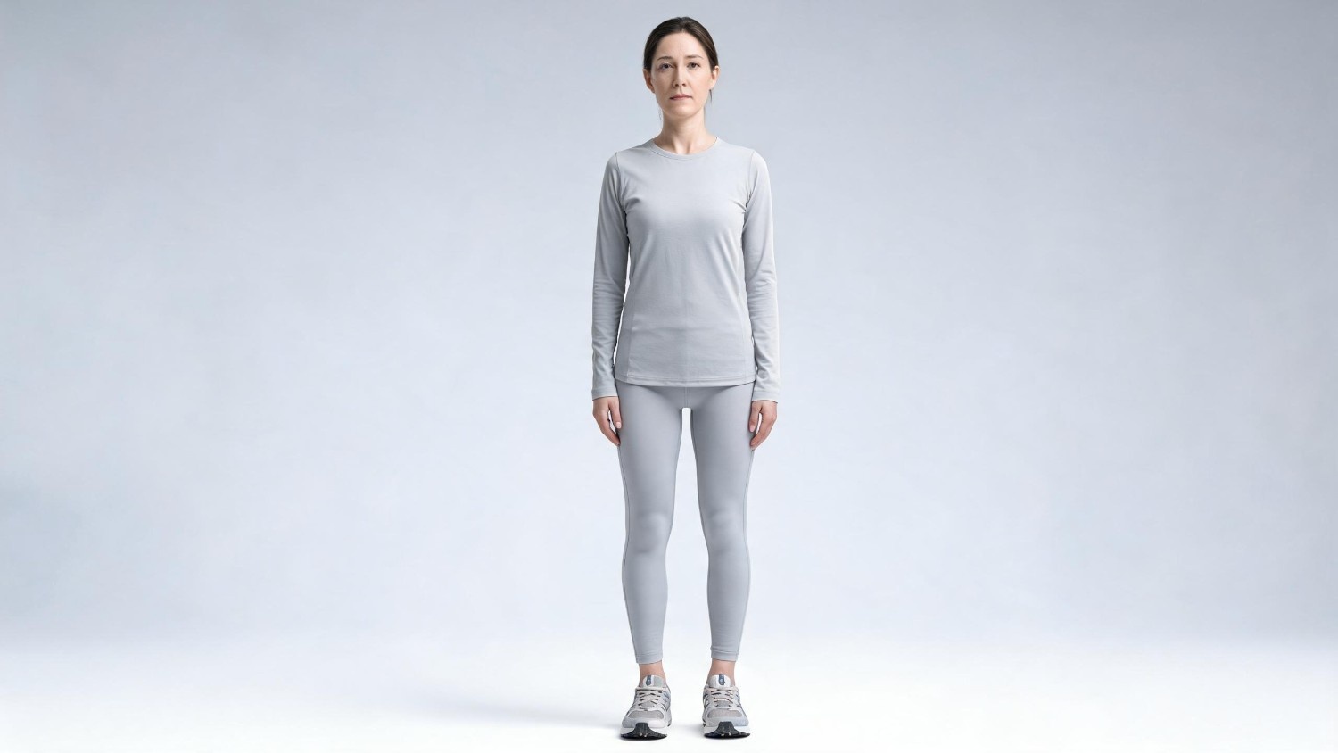 Adult standing in a posture assessment setting illustrating the relationship between flat feet, body alignment, and movement mechanics.