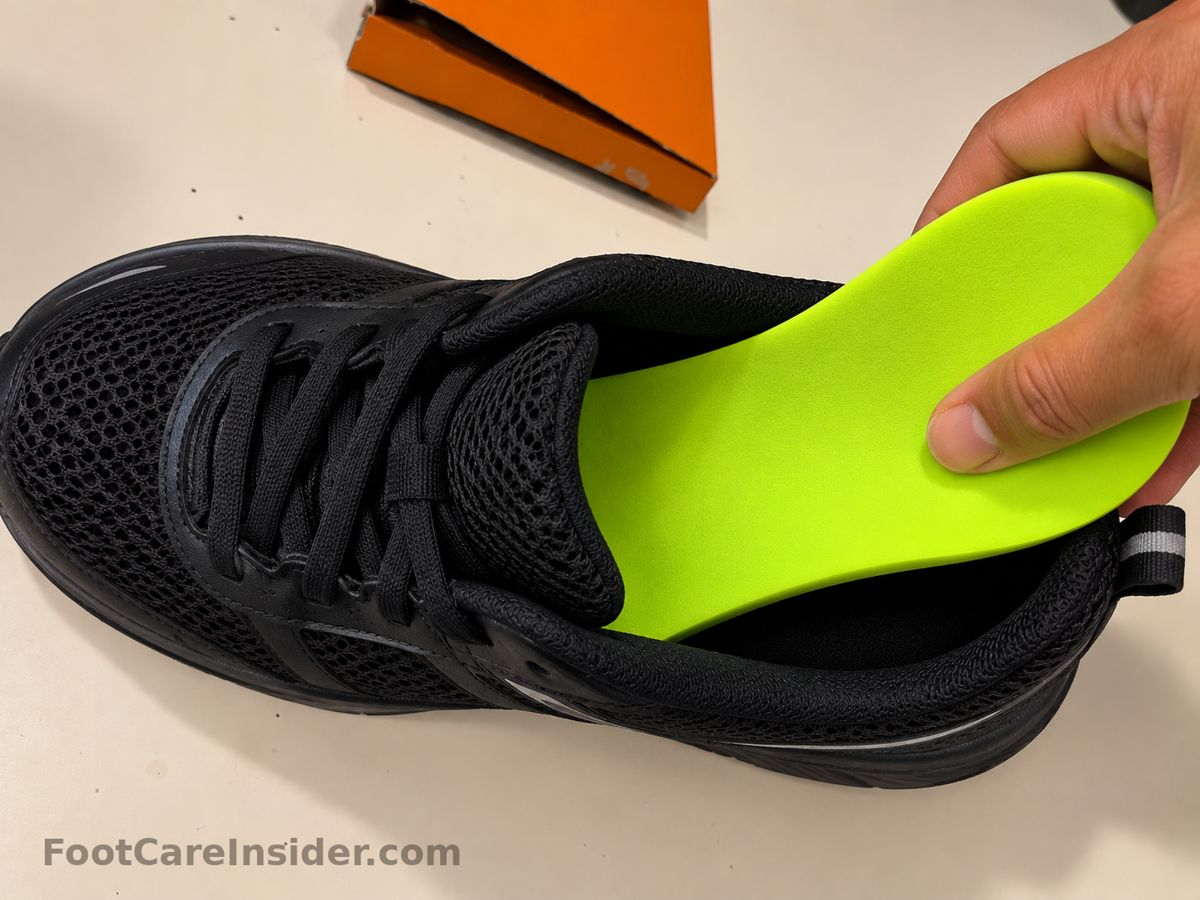 Hand placing a neon green insole into a black running shoe