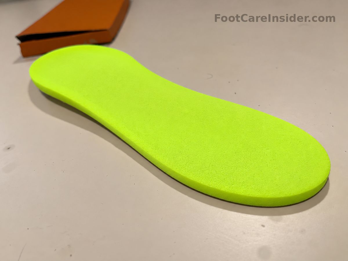 Full-length neon foam insole on a cream surface