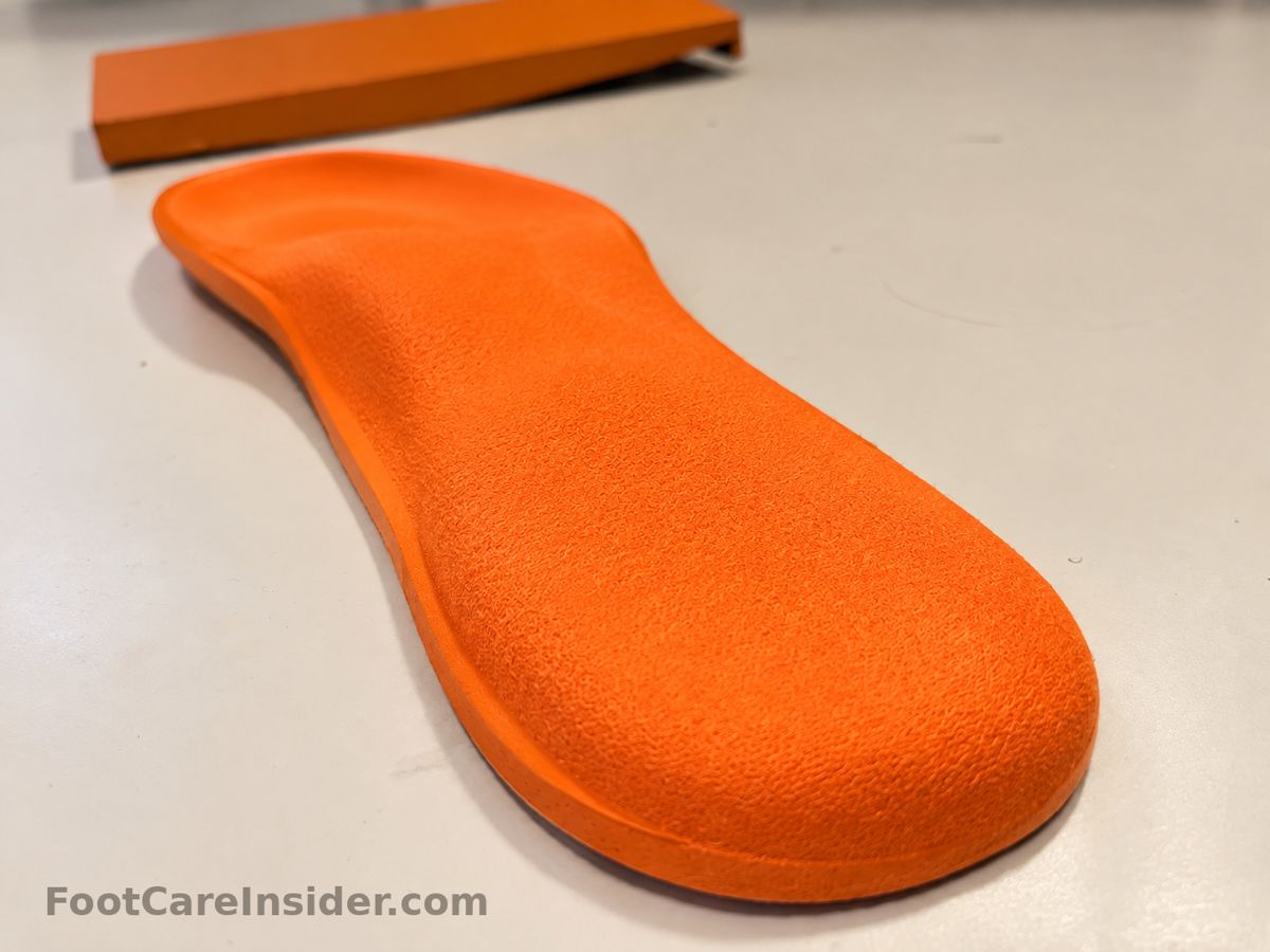 Orange foam insole on a cream surface
