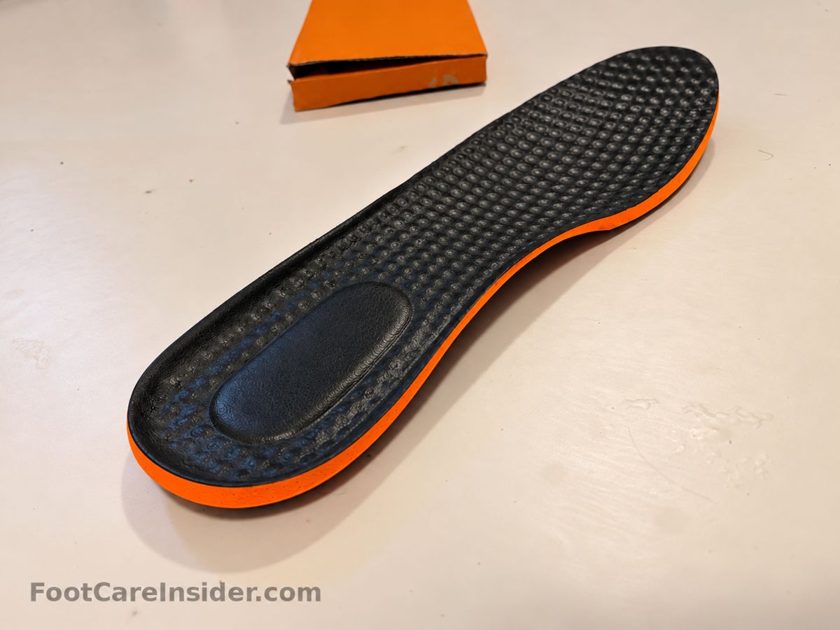 Underside of a black textured insole with an orange edge