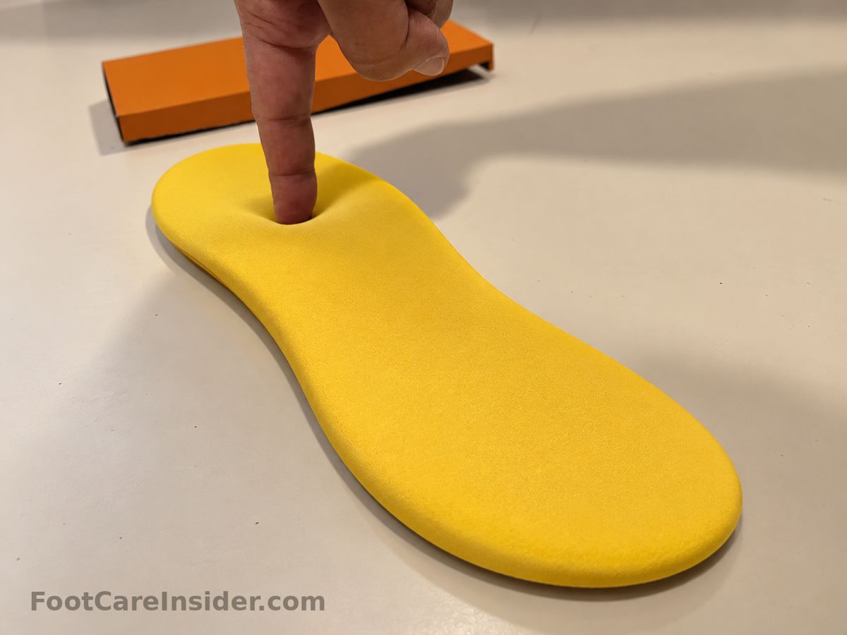 Finger pressing into a yellow foam insole